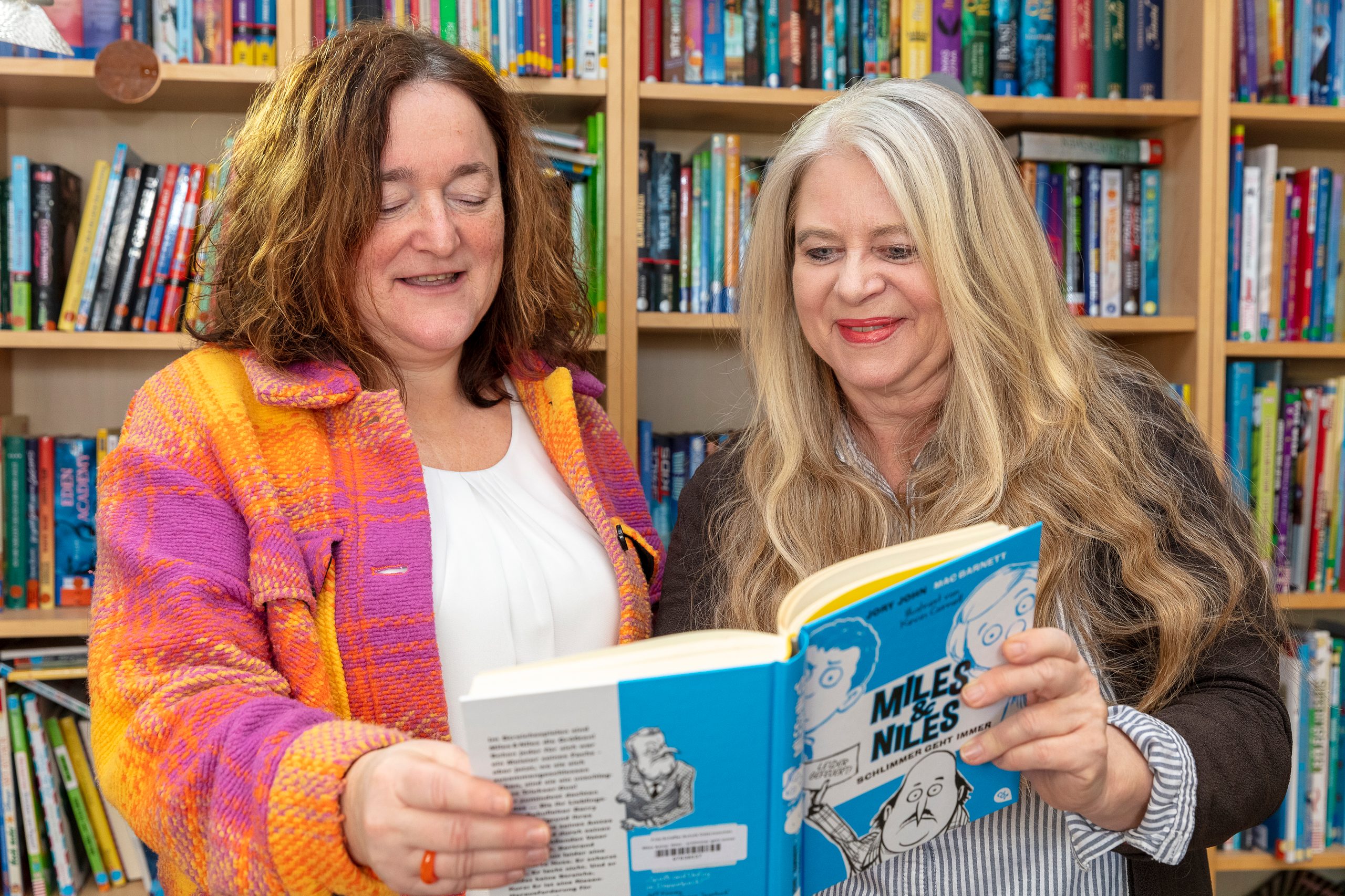 Die Schulleiterin hält ein offenes Buch in den Händen.