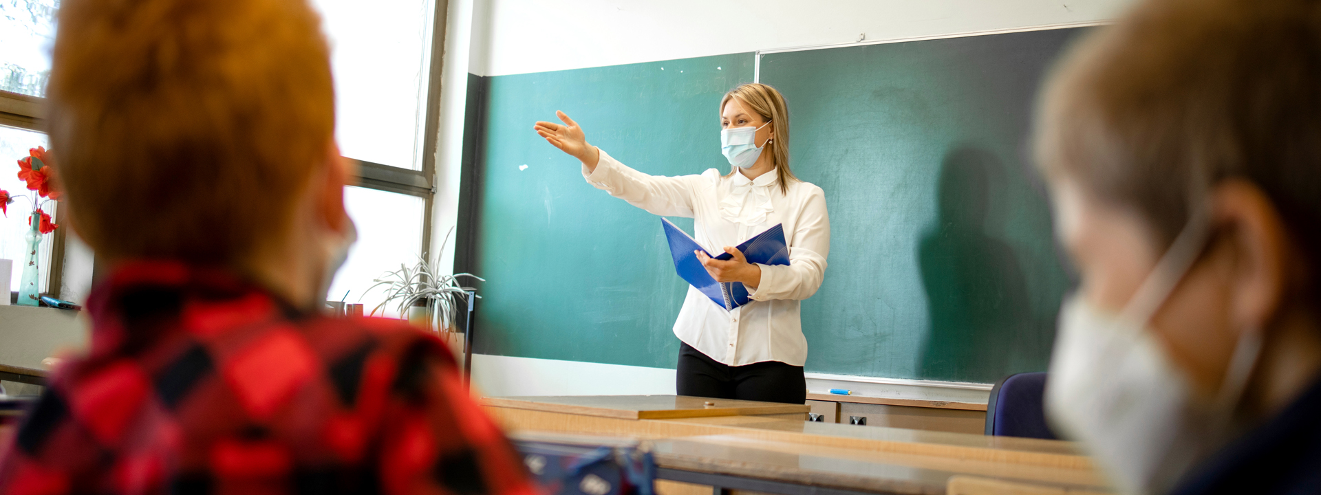 Wo finde ich Hilfe - Lehrerin unterrichtet mit Mund-Nasen-Maske