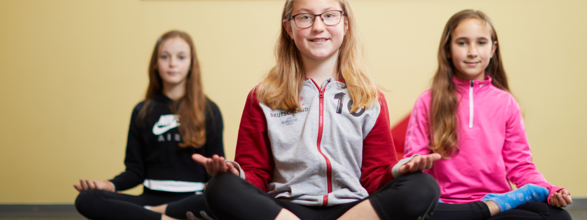 Schülerinnen praktizieren Yoga