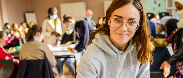 Mädchen mit Klassenzimmer im Hintergrund