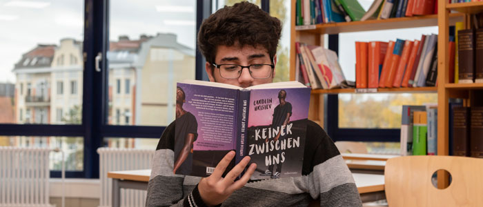 Schüler liest in Schulbibliothek