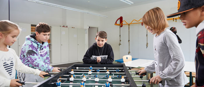 Schüler und Schülerinnen spielen Tischfußball