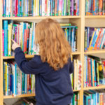 Schülerin vor Bücherwand